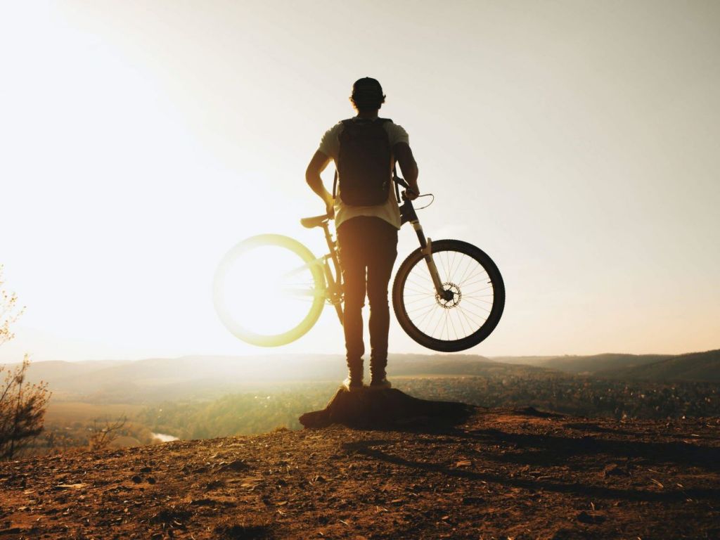 homme qui porte un vélo